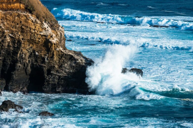 海近くの岩だらけの崖に波が打ち寄せる